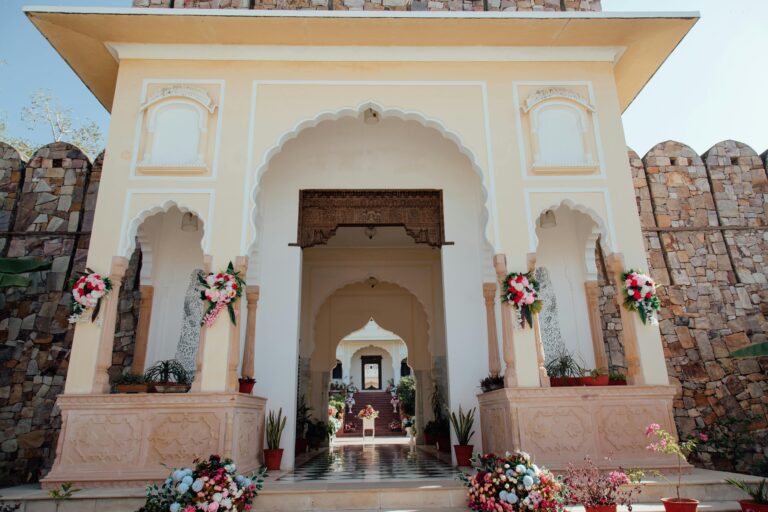 Beautiful Indian architectural entrance decorated with colorful flowers, showcasing traditional design.